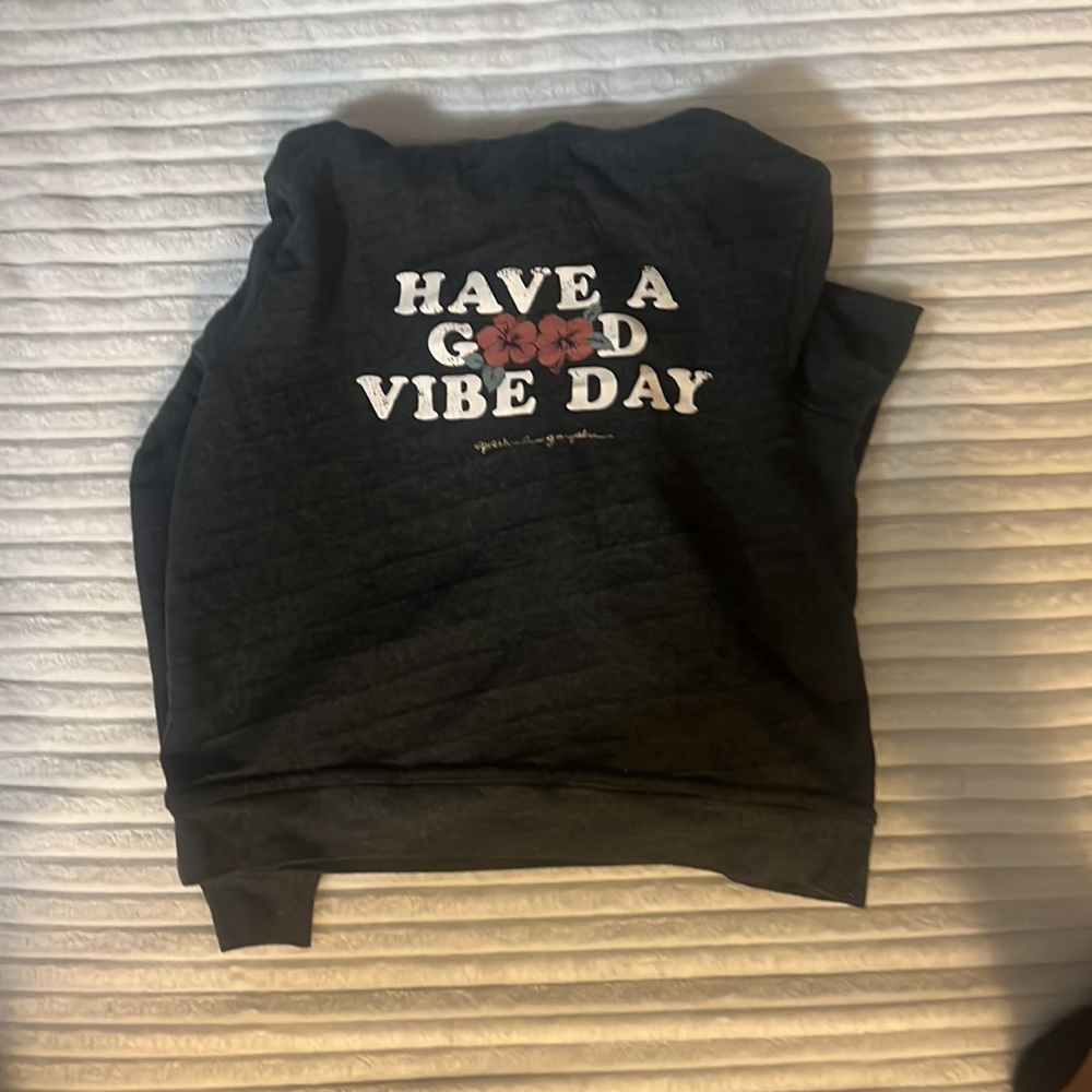 Dark gray hoodie wit have a good vibe day written on the back